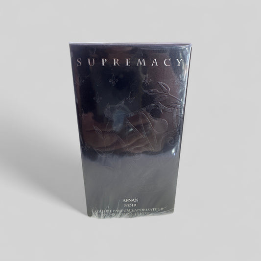 Supremacy perfume packaging on a light gray background