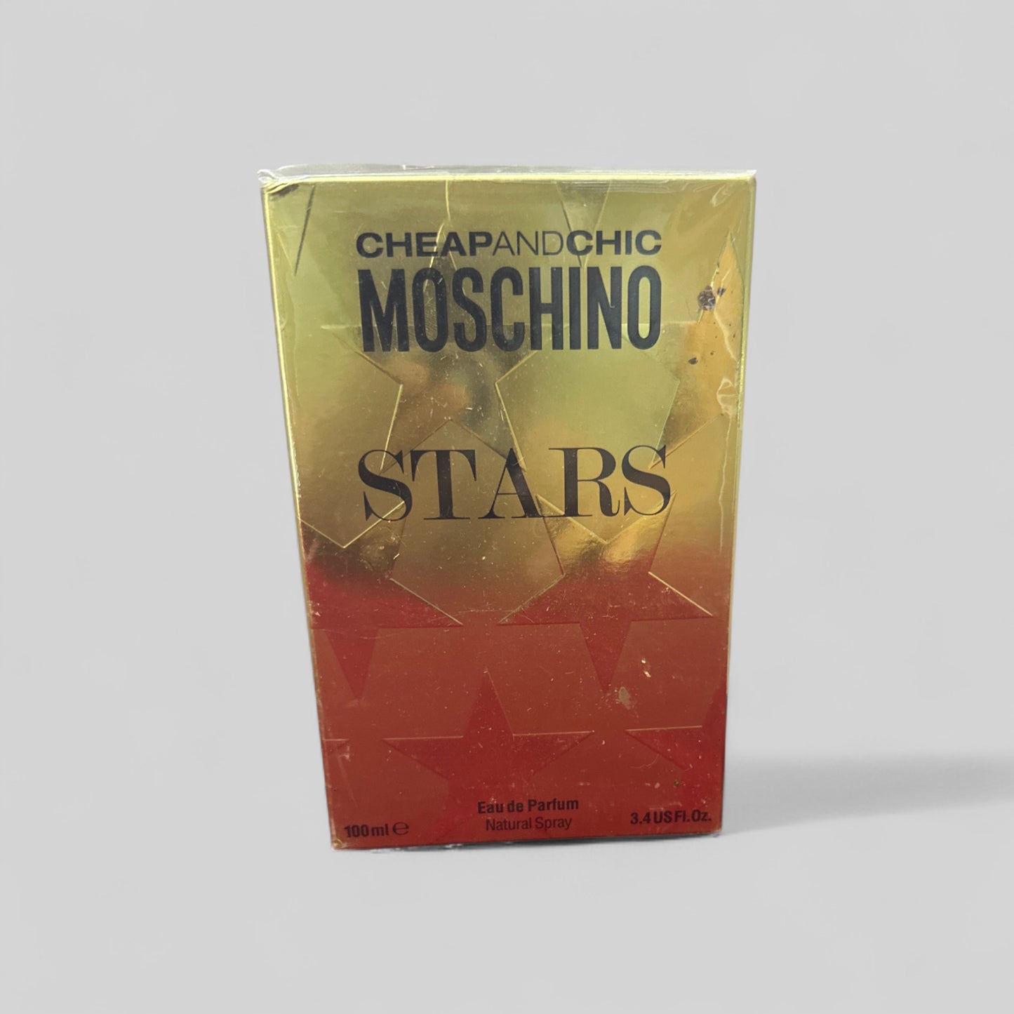 Moschino Stars perfume packaging on a gray background