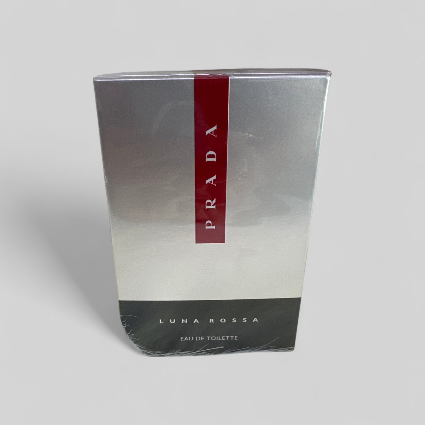 Prada Luna Rossa eau de toilette packaging on a gray background