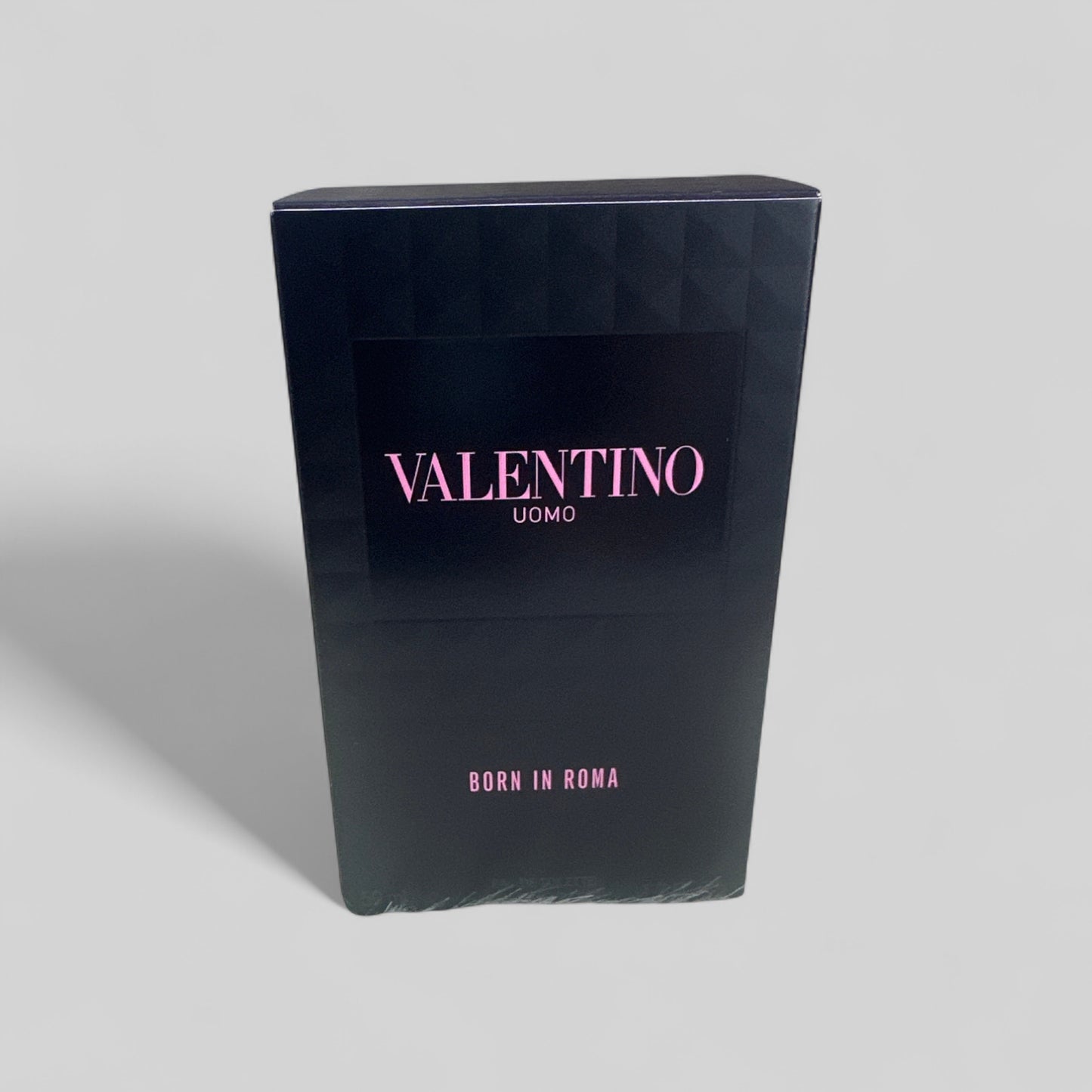 Black packaging box with 'Valentino Uomo' branding on a gray background