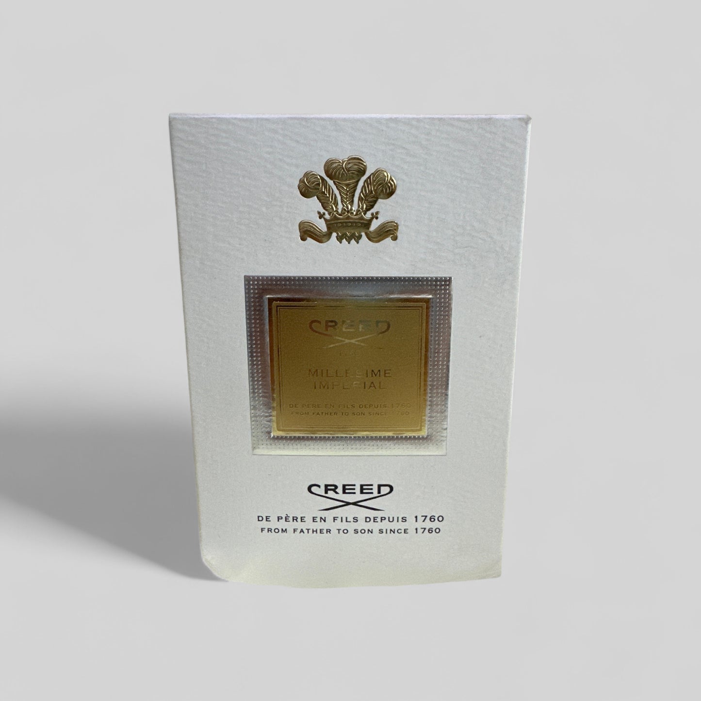 Creed perfume packaging with gold emblem on a white background