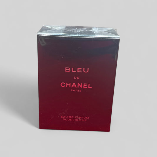 Red box of Bleu de Chanel perfume on a light gray background