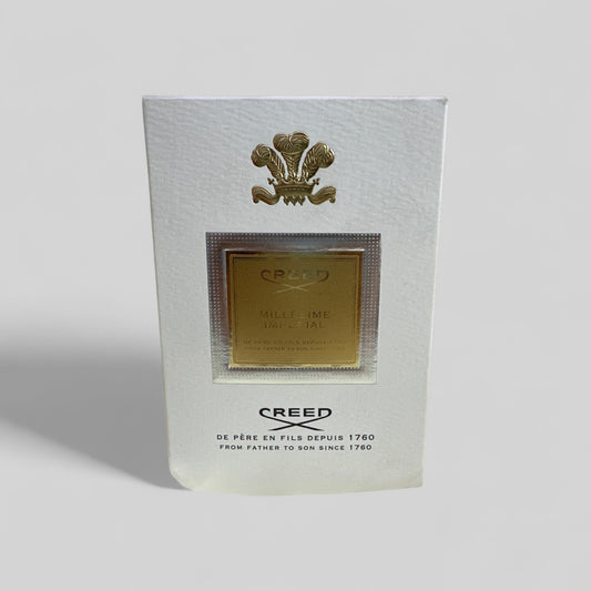 Creed perfume packaging with gold emblem on a white background